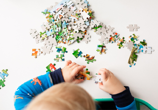 A photograph of a child playing with a jigsaw puzzle