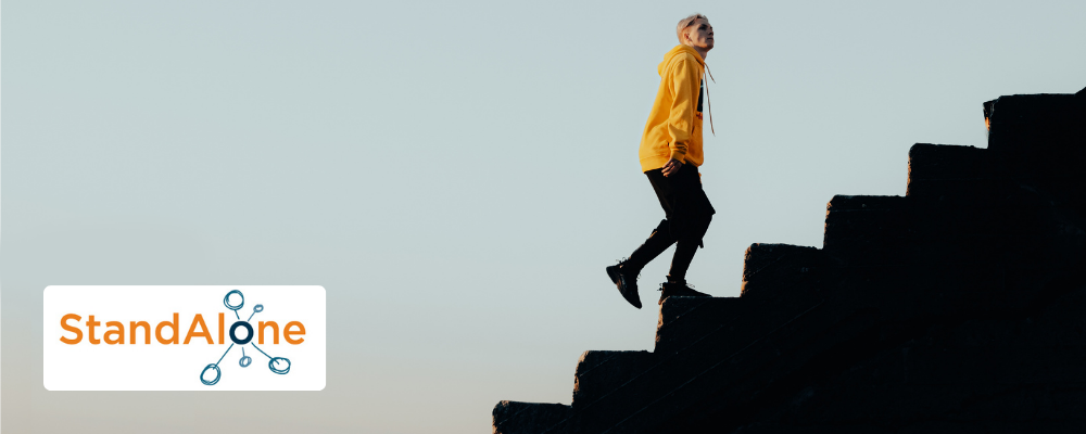 Teenage boy in yellow hoodie walking up some stone steps