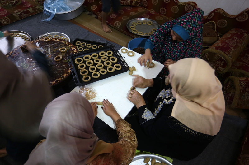 Palestinian women prepare traditional cookies ahead of the Eid al-Fitr festivities