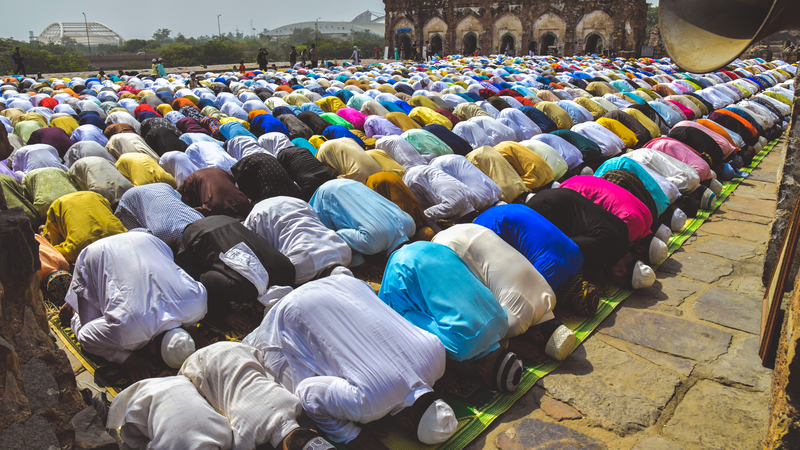 A gathering of Muslim men and children bowing down and offering Namaz prayers on the occasion of Eid`Al-Fitr.