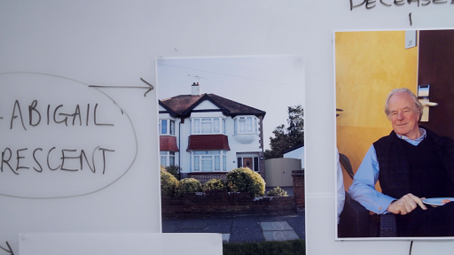 A photograph of part of the police whiteboard, including a photograph of Leonard and Anderson and a photograph of his house.