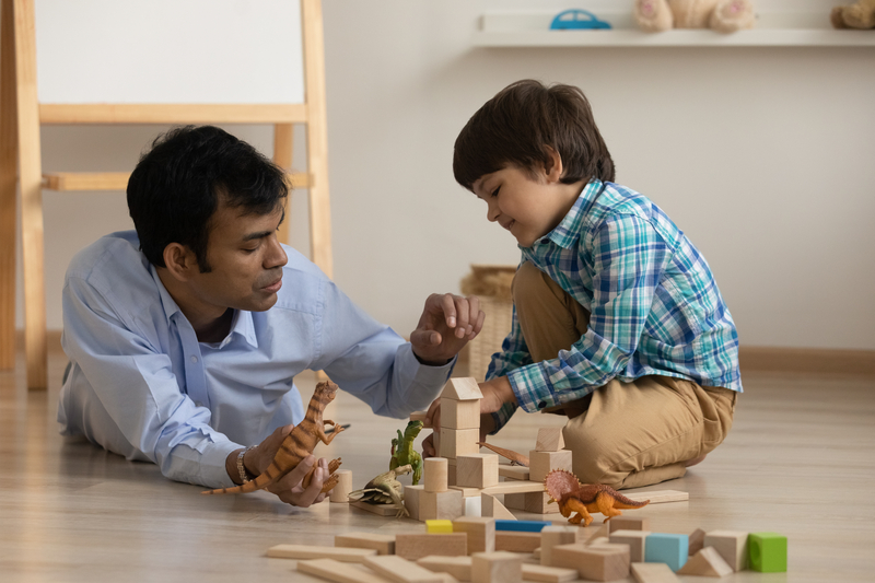 Asian dad and son playing with blocks