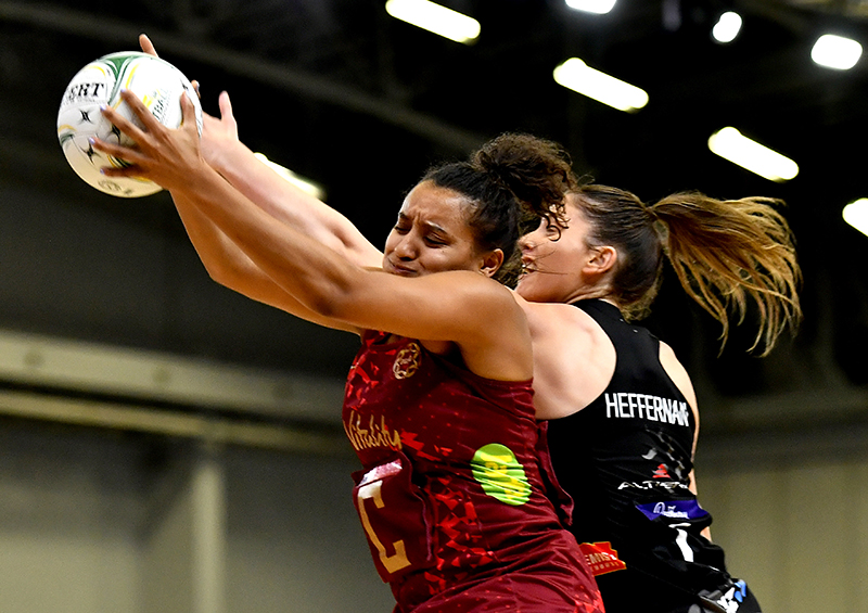 Photograph of England netball player Imogen Allison receiving the ball in a game.