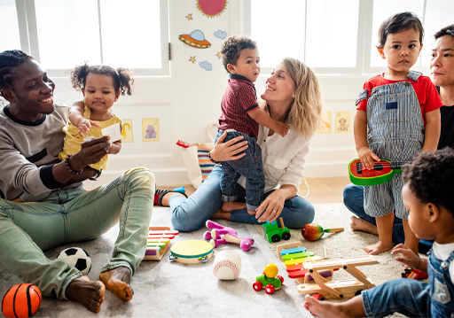 A photograph of a group of children and adults surrounded by toys