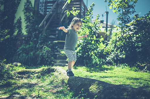 A young child walking along a narrow mound