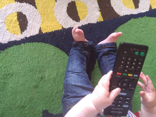 A young child holding a remote control