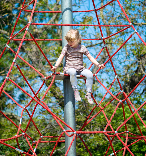 A young girl sat up on a climbing frame