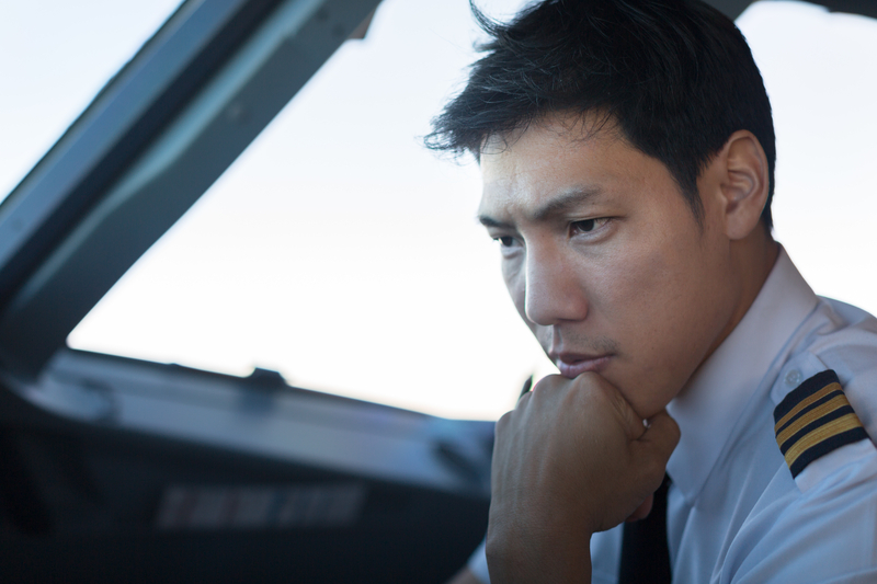 Serious male pilot flying a plane