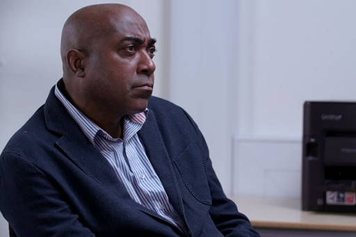 A photograph of SIO Harris sitting on a chair.