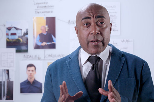 A photograph of SIO Harris in front of a busy white board.