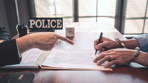 A photograph of someone being forced to write a confession.