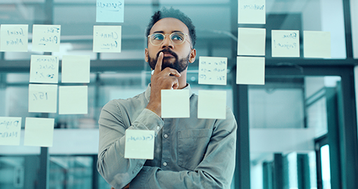 A photograph of someone looking at a collection of post-it notes.
