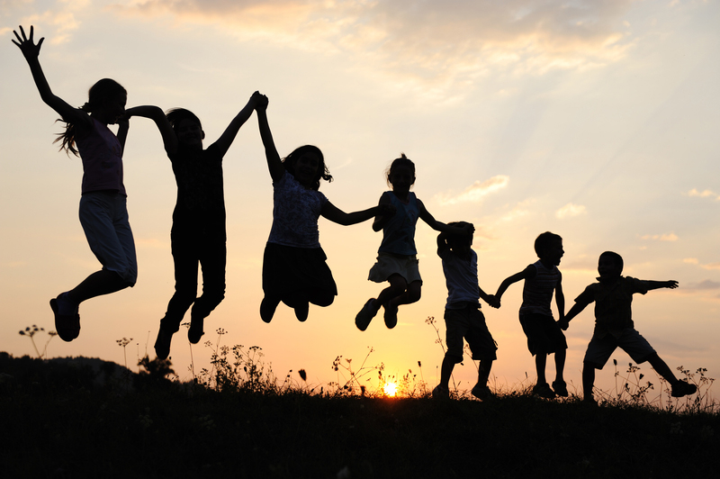 Silhouette of a group of children jumping up in the air