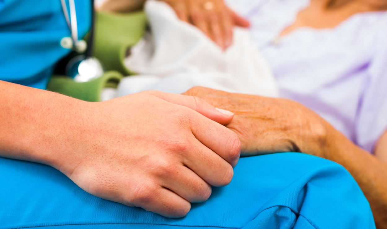 Nurse holding hands with a patient.