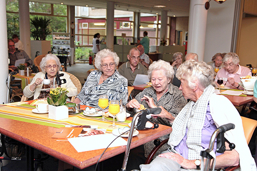 Four elderly ladies sat around a table in a communal area
