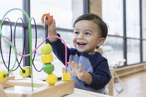 Child smiling whist playing with a toy