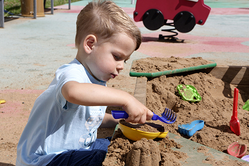 A child playing with sand in a sand pit