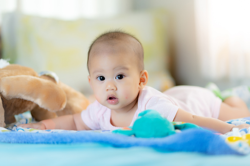 A baby on the floor doing tummy time