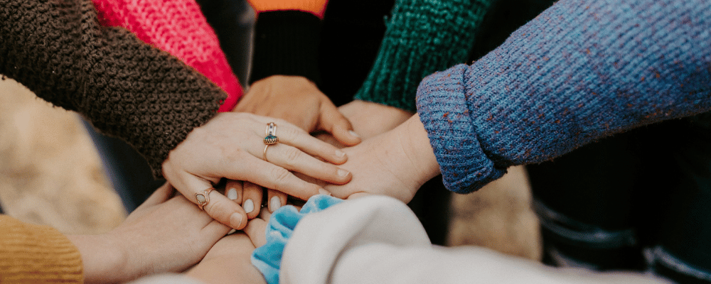 Pobl yn dal dwylo mewn cylch