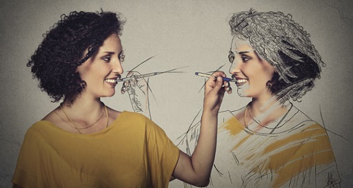Photograph of a young woman drawing a sketch of herself, set against a grey background.