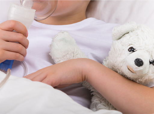 A photograph of an ill child holding a stuffed toy