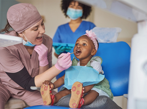 A photograph of a child being checked by a dentist