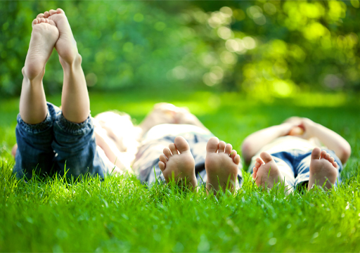 A photograph of a group of children laying in the grass