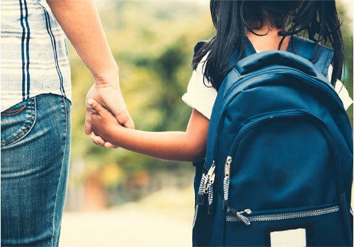 A photograph of a young child holding the hand of an adult