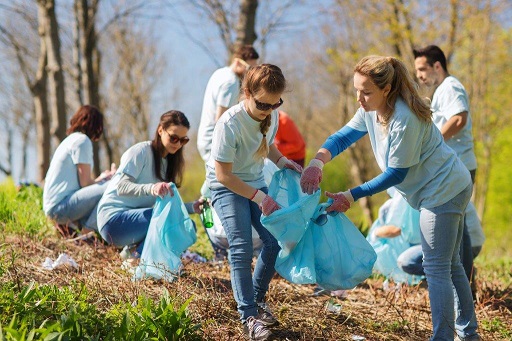 A photograph shows a group of people pucking up litter.