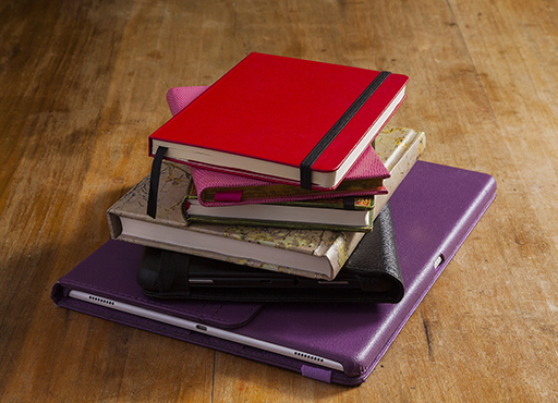 A colourful pile of electronic tablets and notebooks.