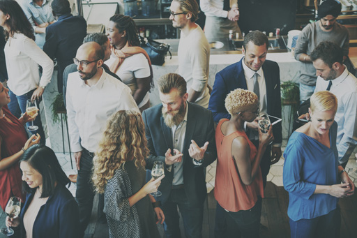 A group of people talk over drinks at a work-place social event.