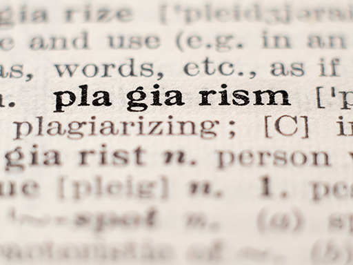 Zoomed in photo of the word ‘plagiarism’ in a dictionary.