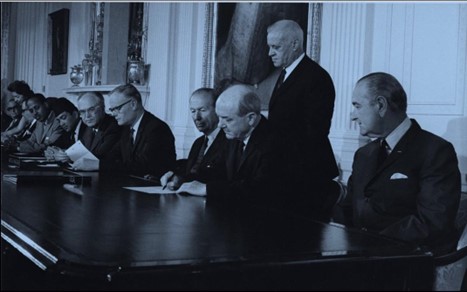A photograph of several politicians sitting at a desk.
