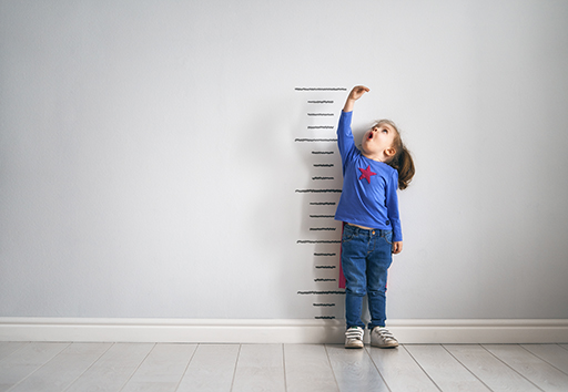 A child measuring their height against a wall.