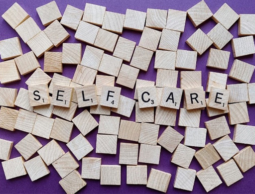 Scrabble tiles spelling out ‘Self care’.
