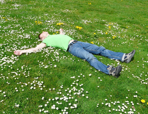 A person laying down on the grass.