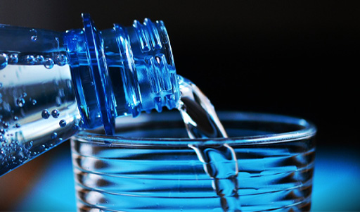 Water being poured from a bottle into a glass.
