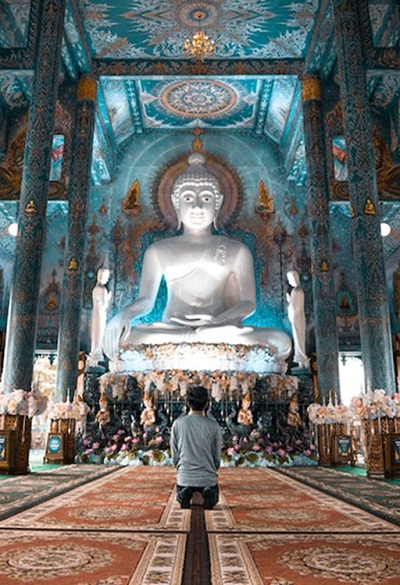 A person kneeling in a temple.