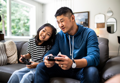 An adult and a child playing a computer game together.