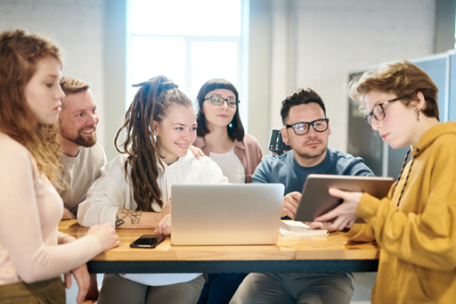 A group of people around a laptop.