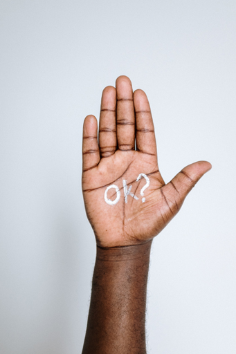 A hand with the word ‘OK?’ written on the palm.