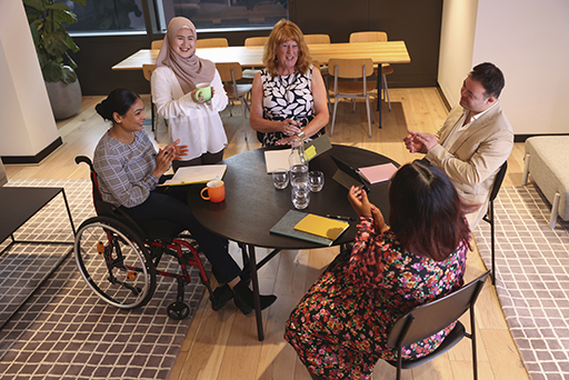 Photograph of a group of people discussing round a table.