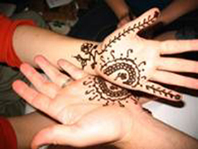 A photograph of two hands with henna patterns on them.