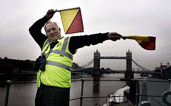 Photo of a man signalling with flags.