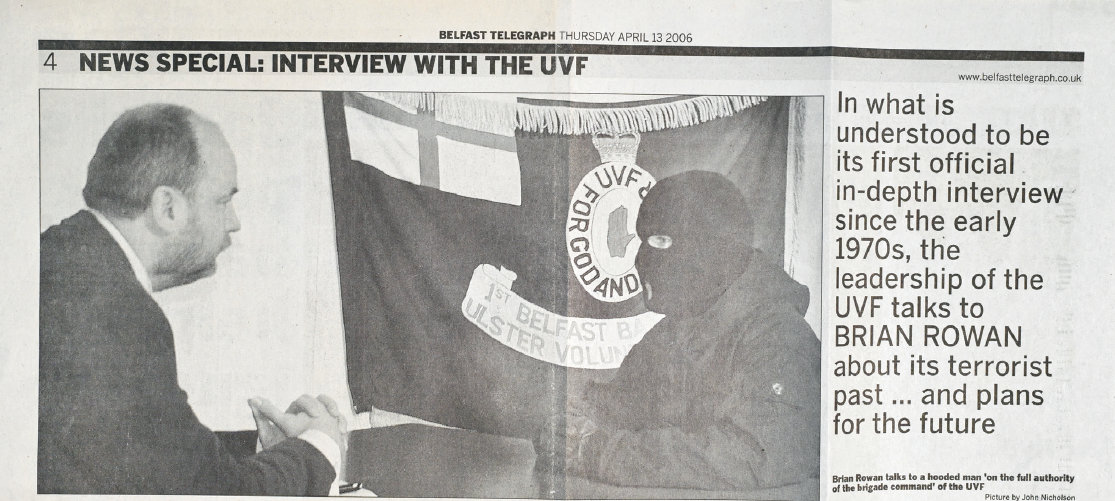 Paper snippet from a press report. The photograph shows a reporter in conversation with a man wearing a balaclava. See details below for text transcript.