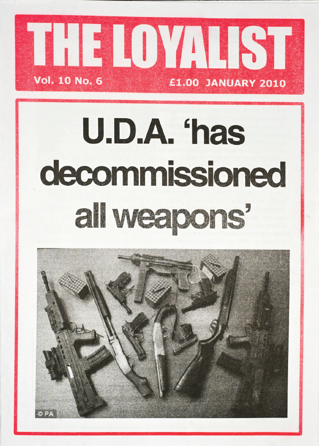 Page from a paper called 'The Loyalist'. The photograph shows a selection of guns. The headline states UDA 'has decommissioned all weapons'.
