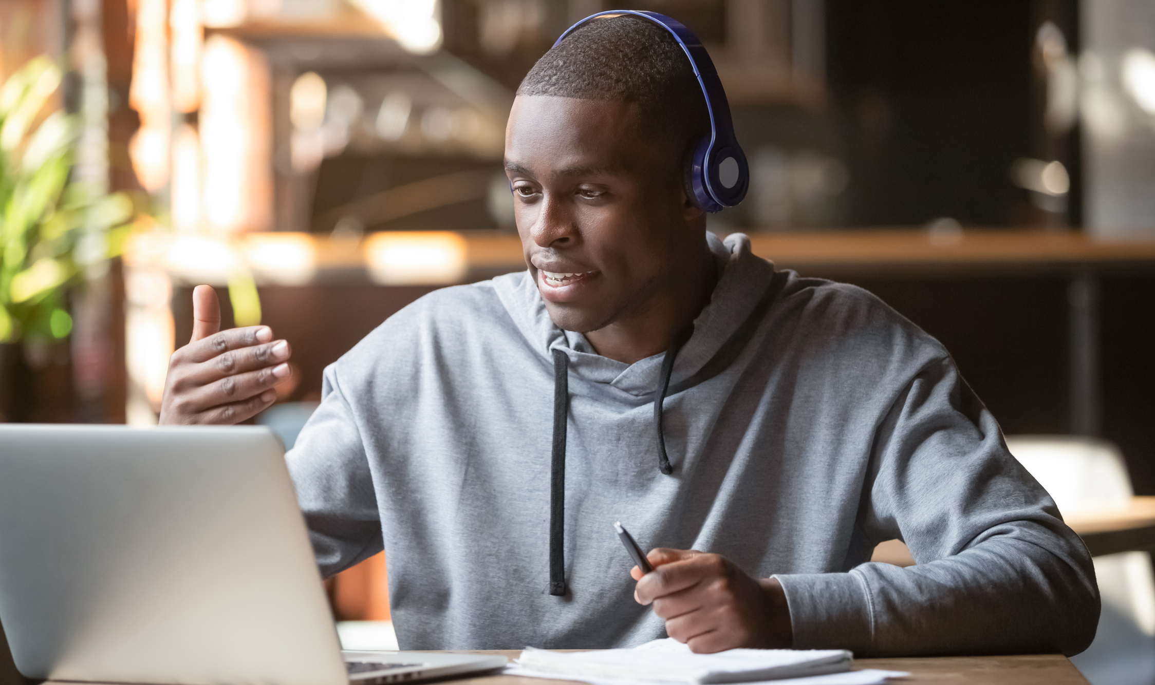 Male student in headphones making video call using laptop