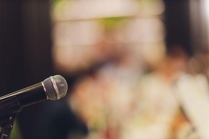 Close up of microphone in a blurred out concert hall 
