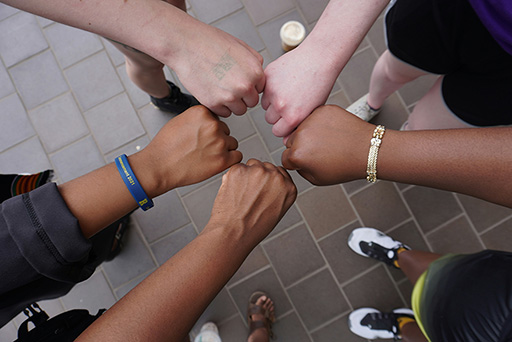 Photograph of multiple hands together.
