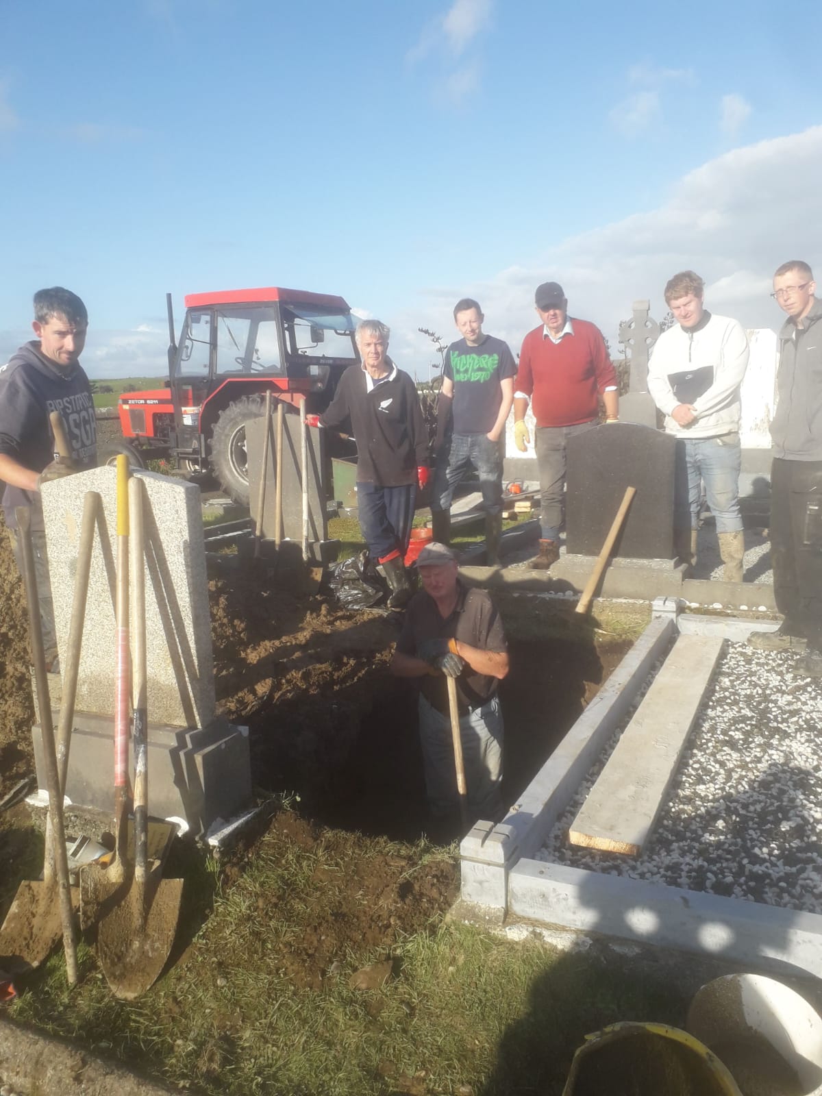 A group of men digging a grave. September 2019.